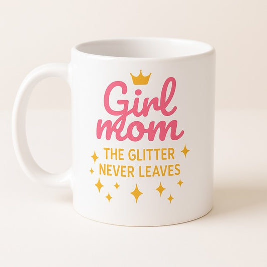 Λευκή κεραμική κούπα με τη φράση "Girl mom – The glitter never leaves" σε ροζ και χρυσό, με σχέδιο κορόνας και αστεριών, ιδανική για μαμάδες κοριτσιών- The Gift Box thegiftbox.gr